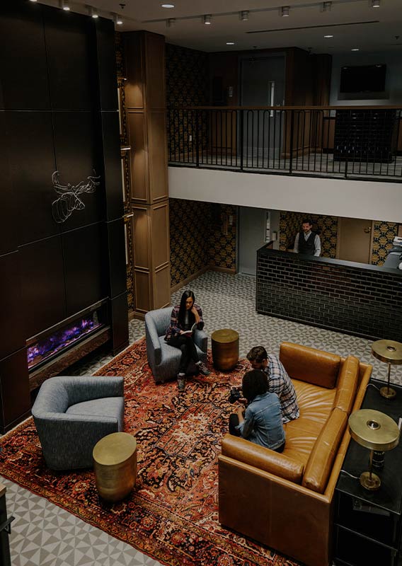 A hotel lobby with people sitting on couches and chairs.
