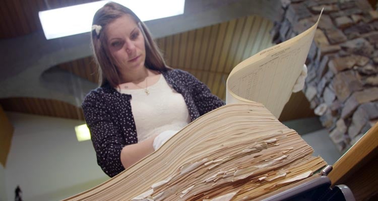 A researcher looks through historic documents from the Mount Royal Hotel.