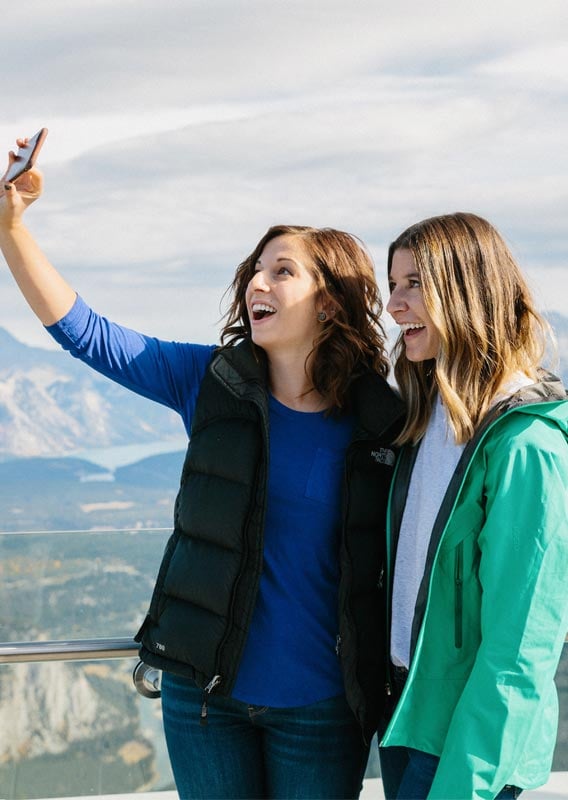 Two people take a selfie at the top of the Banff Gondola