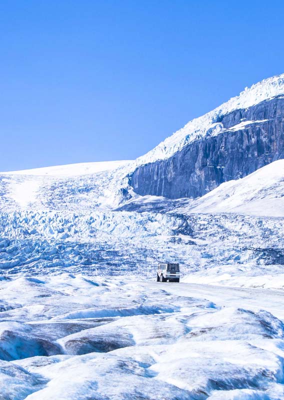 An Ice Explorer drives along the Athabasca Glacier towards the Columbia Icefield