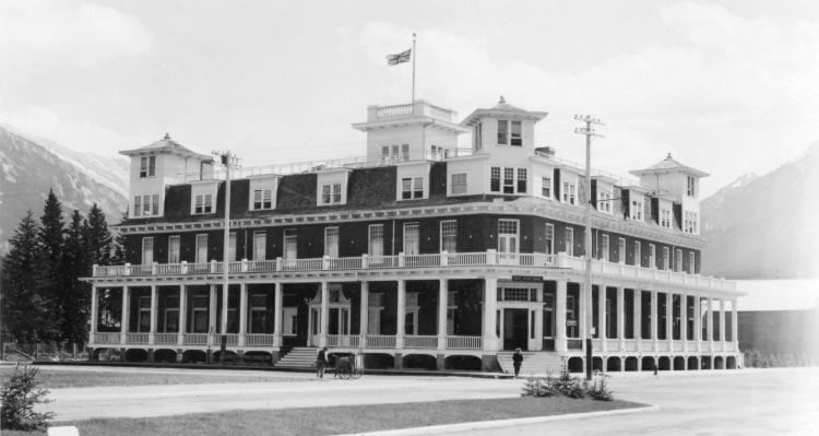 A black and white photo of a historic hotel with wraparound balconies.