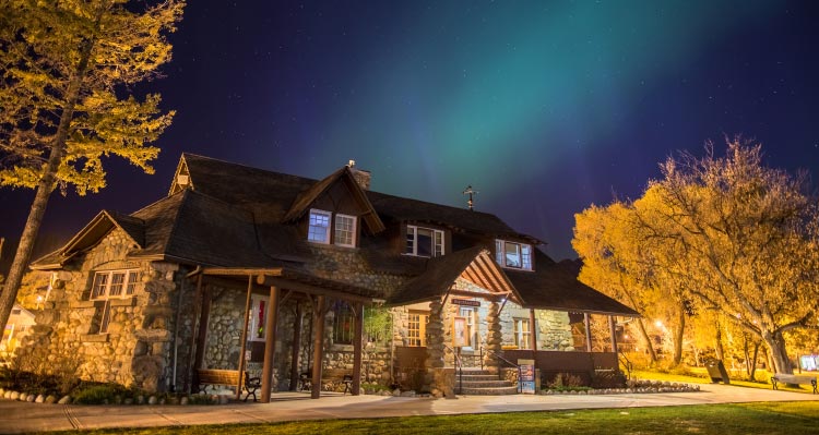 The Jasper Information Centre under a night sky with aurora.