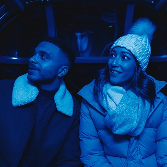 Two people ride in a gondola cabin.