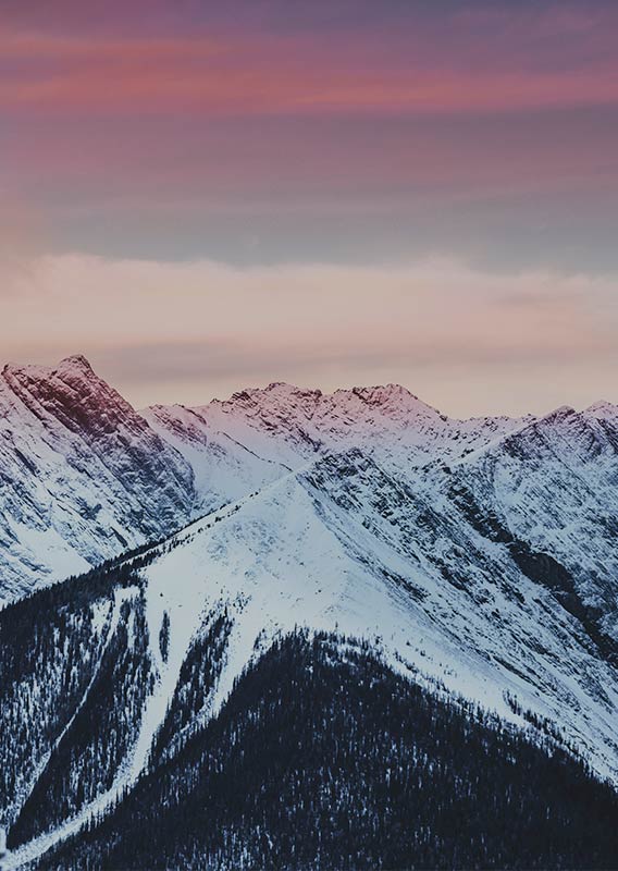 Mountains in winter with a pink sunset sky