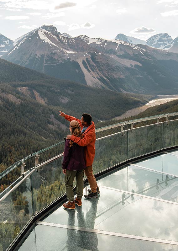 A couple points to the distance standing on the skywalk.