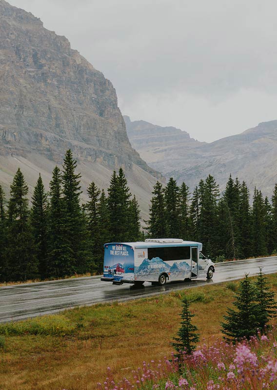 Brewster Express bus driving along highway with towering mountains