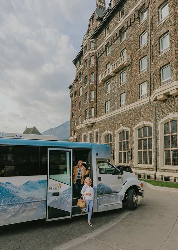 Brewster Express bus parked at the Fairmont Banff Springs while guests disembark