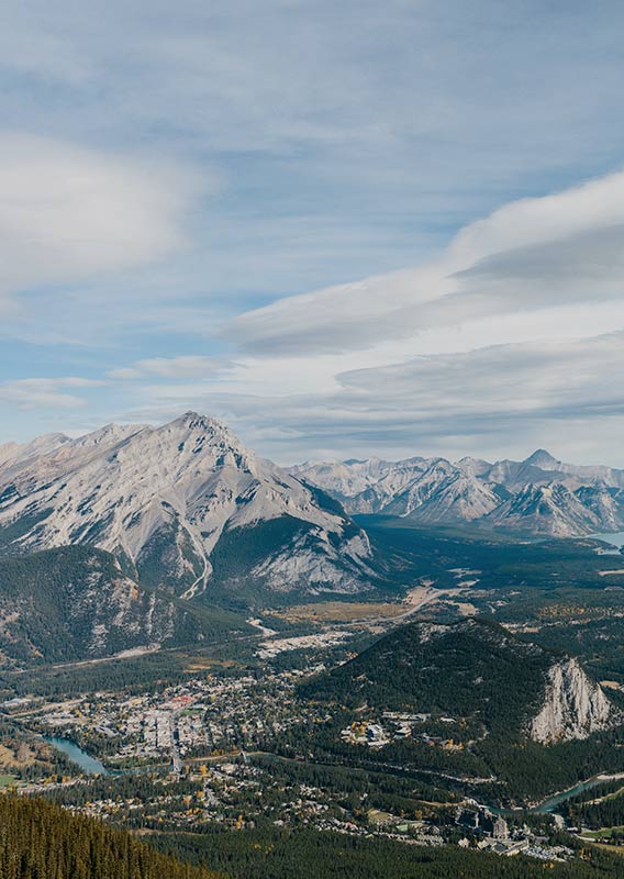 A view into a wide valley with a small town between tall mountains.