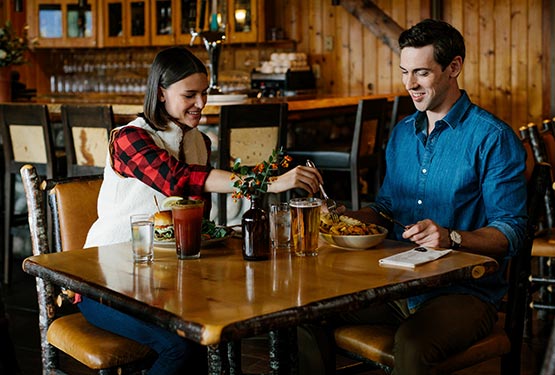 Two people sit for dinner at a restaurant table.