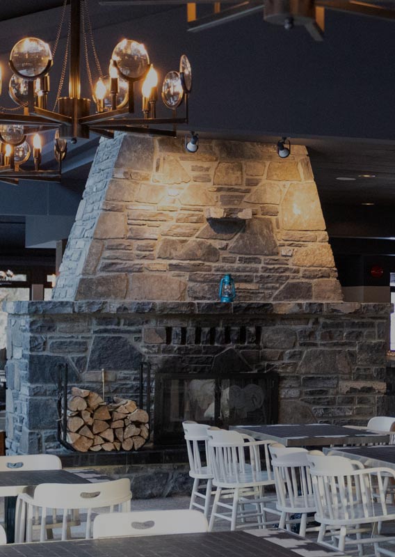 A dining room with a large stone fireplace