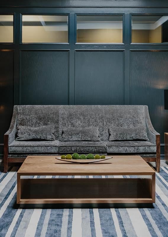 A hotel lounge with couch and coffee table.