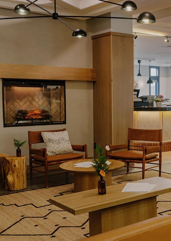 A hotel lounge with couch and coffee table next to a restaurant bar.