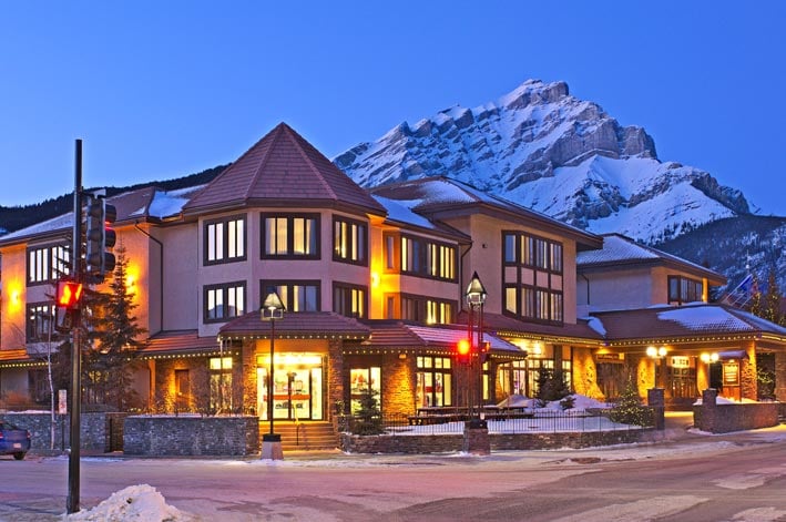 The Elk + Avenue Hotel at a street corner with a mountain rising in the background