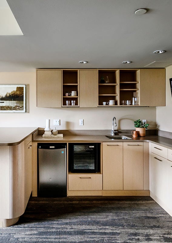 A hotel room kitchen with bar stools.