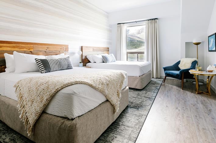 Glacier View Lodge room with two queen beds and views of a forested mountainside
