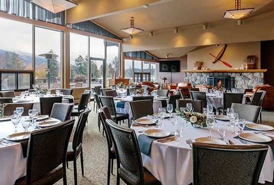 A large room set up for a banquet with floor-to-ceiling windows.