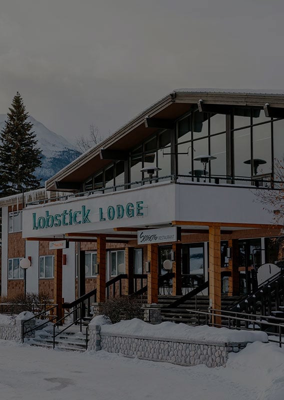 The Lobstick Lodge set with a snow-covered mountain rising in the background.