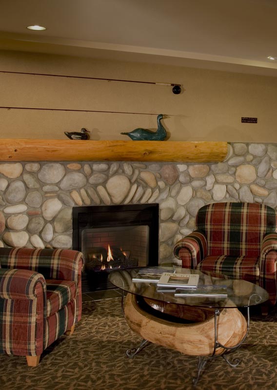 The lounge in Lobstick Lodge with chairs and fireplace