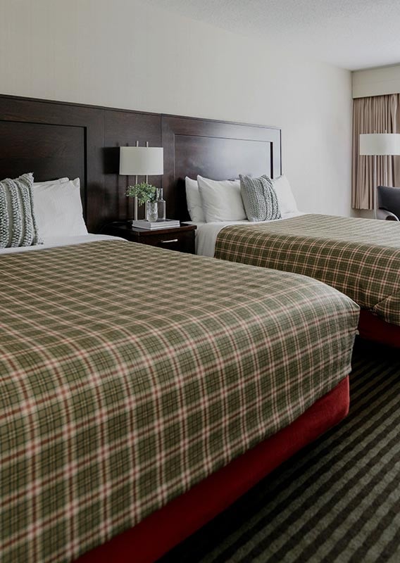 Deluxe room with two queen beds and plaid bedspreads