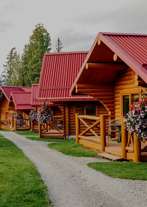 A gravel walking lane next to rows of red roof cabins in the summer.