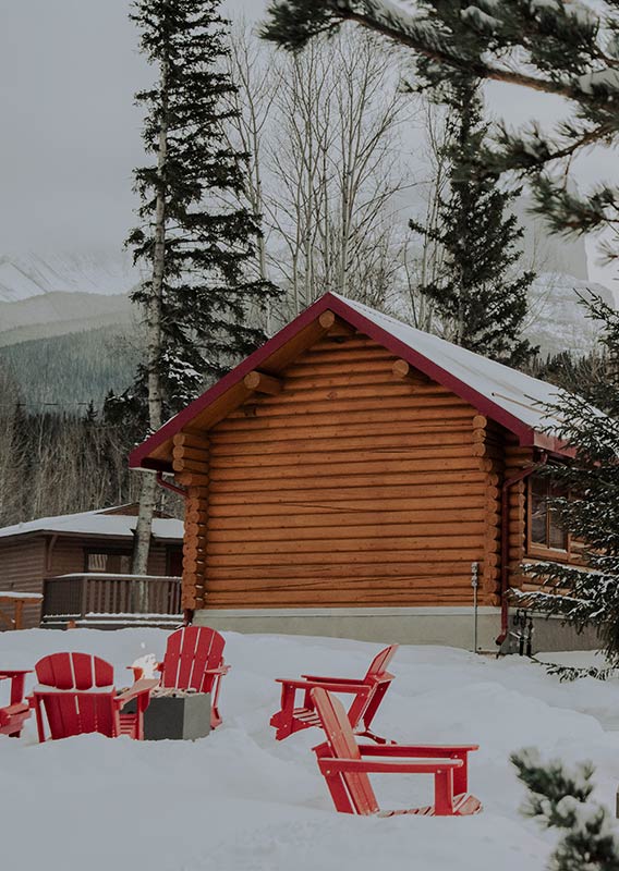 Red outdoor chairs in the snow outside the cabins