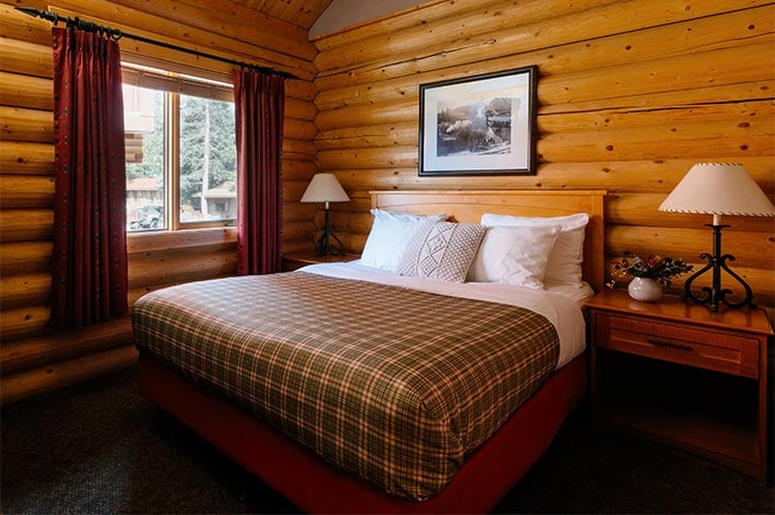 A bed in a wooden cabin