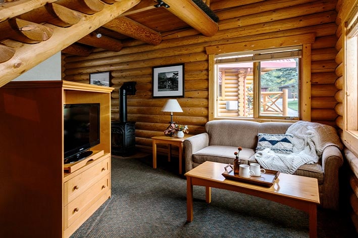A living area in a wooden cabin, with sofa and coffee table.