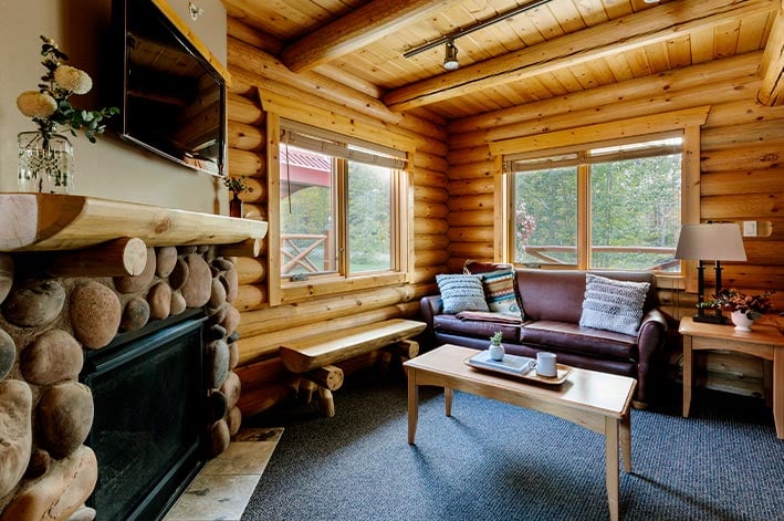 A living room with couch, chair, coffee table and fireplace