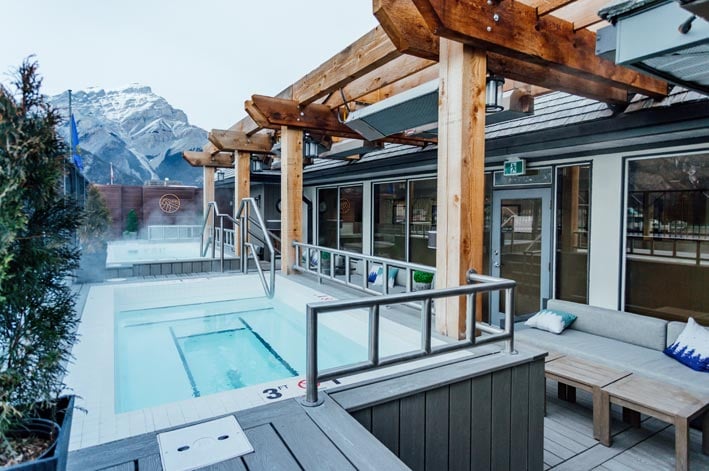 Two hot tubs on a rooftop patio with a mountain view