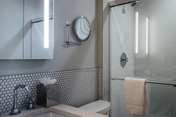 Sink, toilet mirrors and shower in a bathroom.