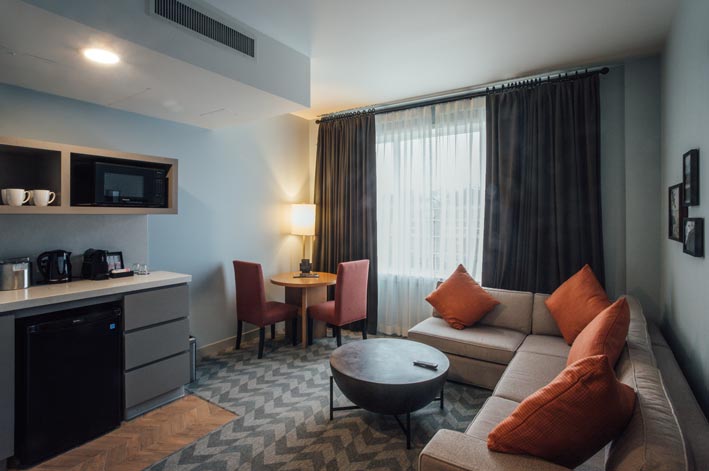 A lounge and kitchenette in a hotel room.