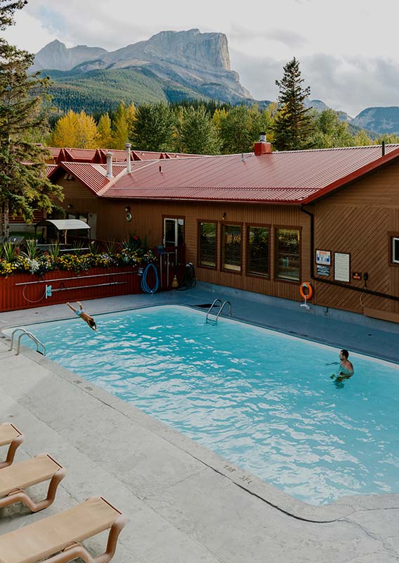 An outdoor swimming pool below a mountain vista.