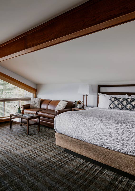 A hotel room with bed and lounge area.