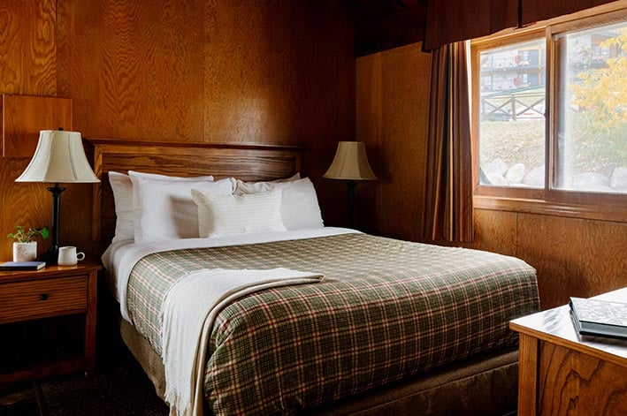 A bed in a wooden hotel room