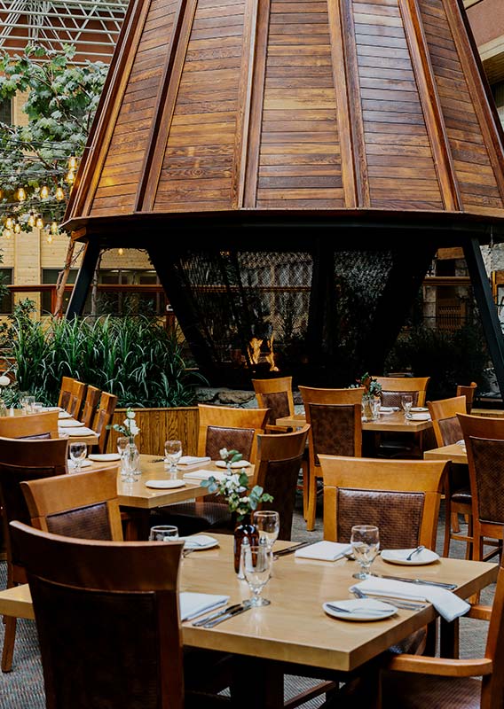 A restaurant set for dinner in a tall atrium