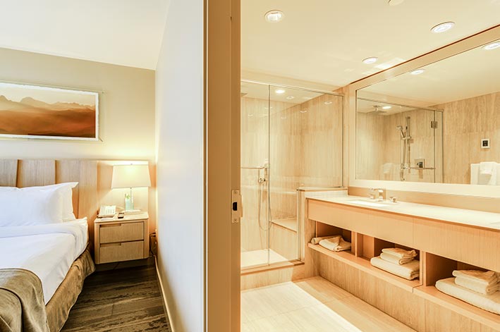A hotel room with adjacent large bathroom