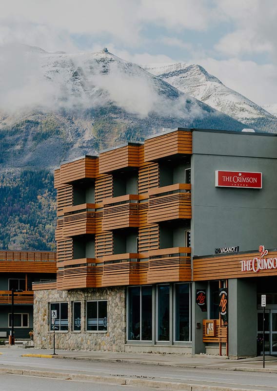 Exterior of The Crimson with snow-peaked mountains in the background