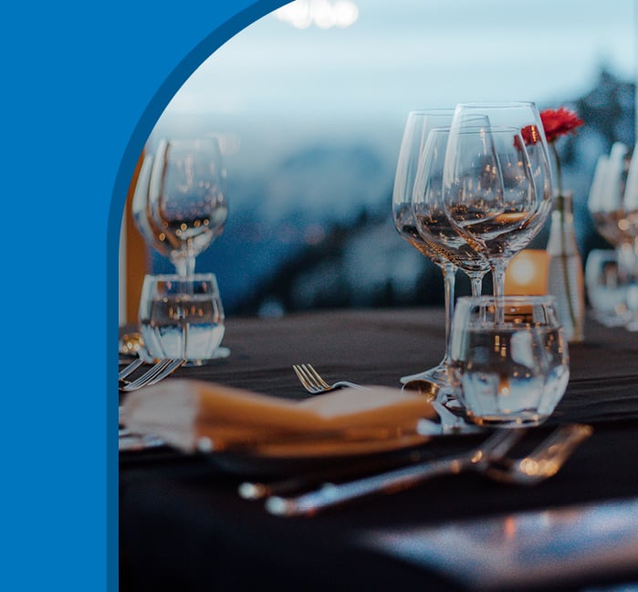 A long dining table with place settings with the word "Cheer" overtop..