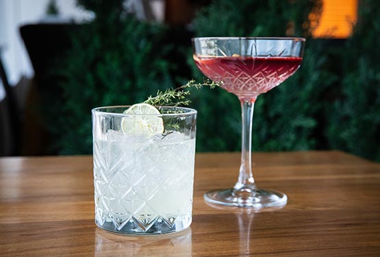 A white and a red cocktail arranged on a table.