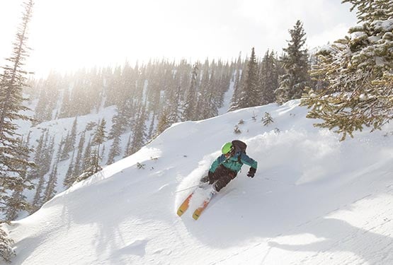 A person skiing down a steep slope.