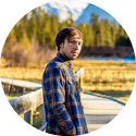 Photographer Alahn Gacitua stands on a wooden boardwalk.