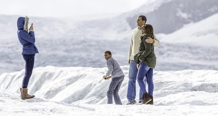 A family poses for a photo on an icefield