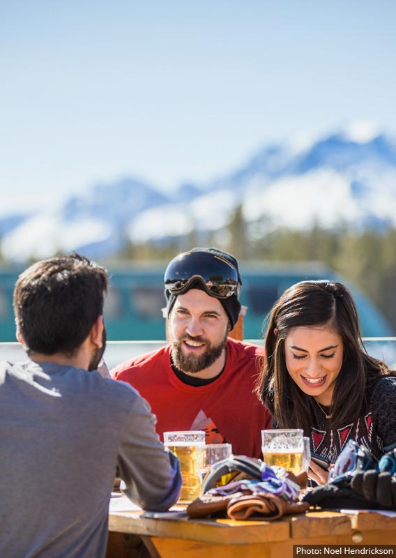 Five people look out to mountains and lakes from a lookout point