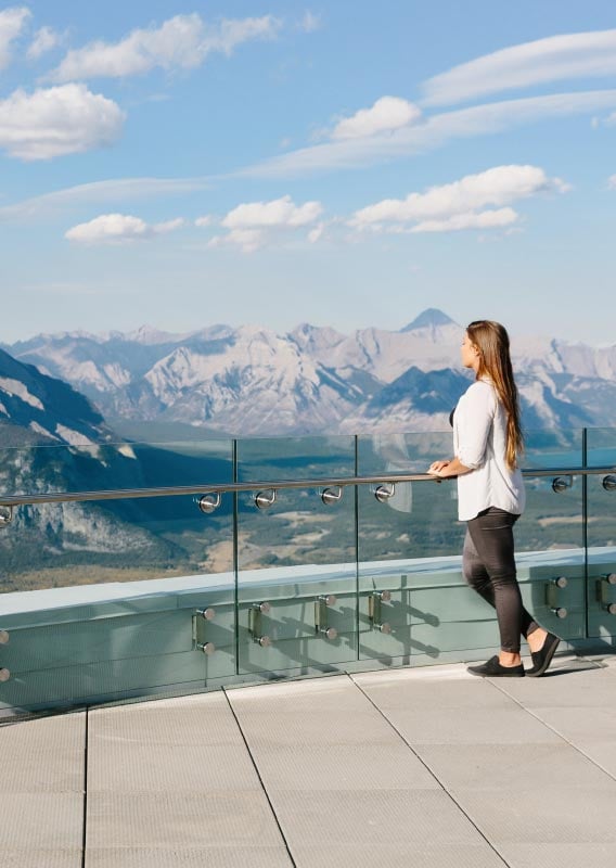 Groups of people take photos at the top of the Banff Gondola