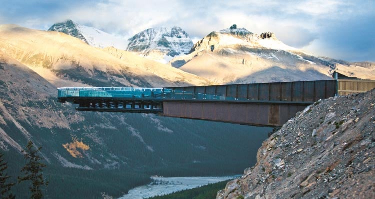 A metal and glass platform extends over a high valley.