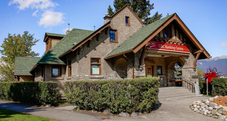 A historic building with pointed green roof and a stone entryway.