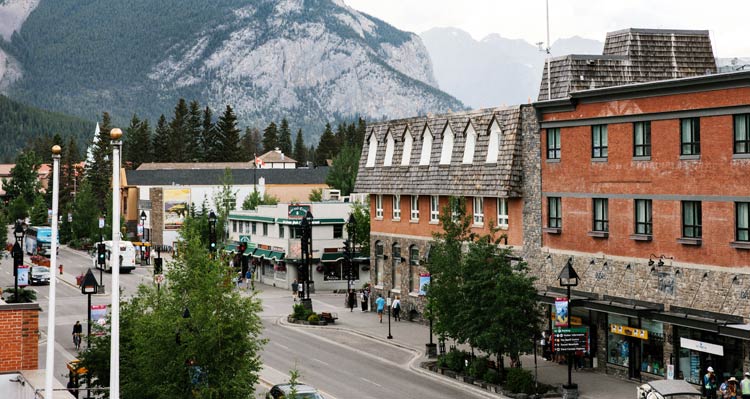 A streetscape with forest-covered mountains behind.