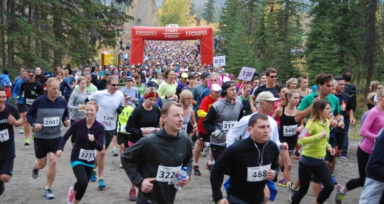 Runners run down a road near the starting line of a race.