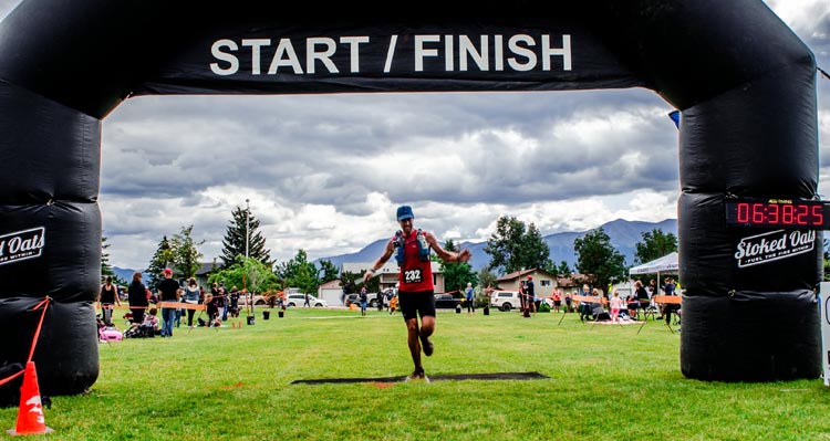 A runner passes through a finish line gateway.