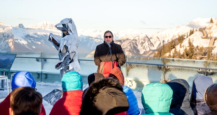 Barry Wesley addresses a group of students on a mountain observation deck.